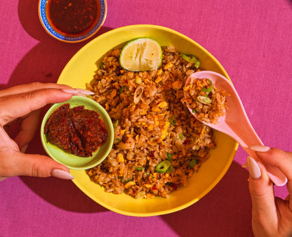 Fried rice with a side of Mei Mei chilli paste on a yellow plate